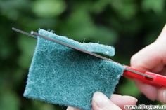 someone is using a pair of scissors to cut the end of a piece of felt