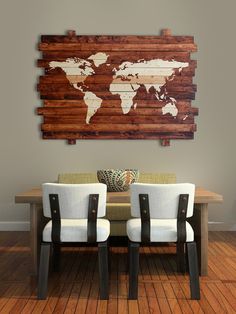 a wooden world map mounted to the wall above a dining room table with two white chairs