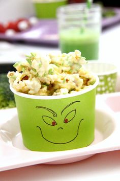 a green cup filled with food on top of a white plate