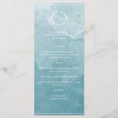 a blue and white wedding menu card on a marble table top with the wording