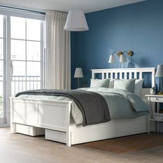 a bedroom with blue walls and white furniture