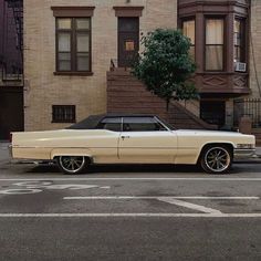 an old car is parked on the side of the street