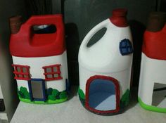 three plastic jugs with houses painted on them