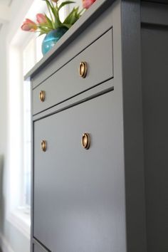 a gray dresser with gold handles and knobs