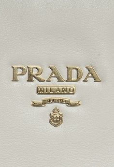 the prada logo is on top of a white leather bag with gold trims