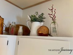 a shelf with some vases and other items on it's top, including an empty card board