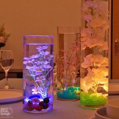 three vases filled with flowers sitting on top of a table