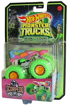 a green monster truck with orange wheels on the front and pink trailer in the back