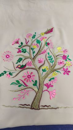 an embroidered pillow with flowers and birds on it