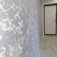 an empty room with a white door and marble floor