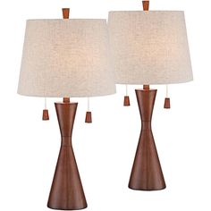 two wooden lamps with white shades on them