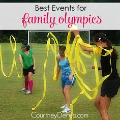 two girls are playing with yellow streamers in the grass and one girl is holding a soccer ball