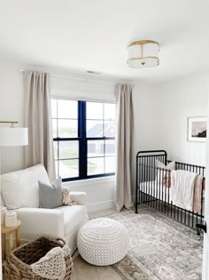 a baby's room with a crib, chair, and window in it