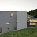 the house is built on top of a hill and has two levels that are connected to each other