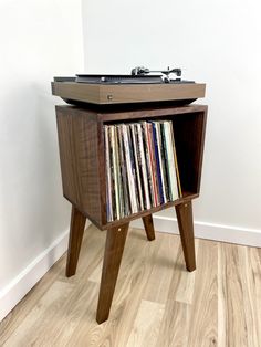 an old record player is sitting on top of a wooden table with records in it