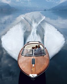 a speed boat speeding across the water with two people in it's back end