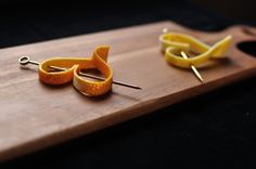 two orange slices cut in half on top of a cutting board with scissors and thread