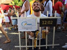 a man standing behind a barricade holding a beer