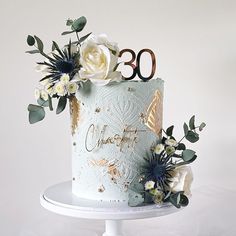 there is a cake with flowers on it and the number 30 written in gold letters