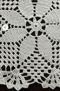 the crocheted doily is made from white yarn and has two holes in it