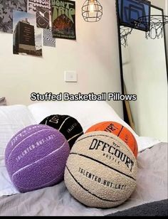 three basketball balls sitting on top of a bed