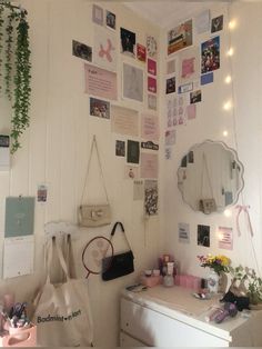 a room with white walls and lots of pictures on the wall, including a mirror