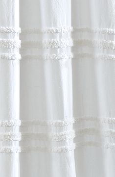 a white shower curtain with ruffled edges