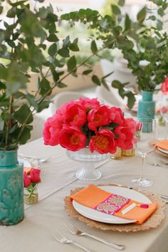 the table is set with flowers and place settings