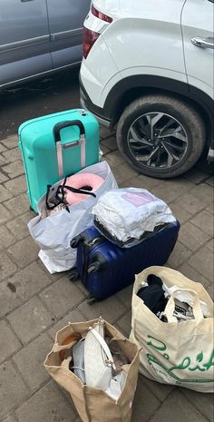 luggage sitting on the ground next to a car