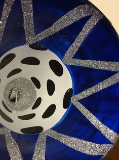 a blue plate with black and white designs on the rim, surrounded by silver glitter