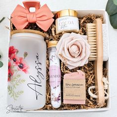 an assortment of beauty products in a white box with flowers and leaves on the side