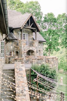 an old stone house with string lights on the front porch and stairs leading up to it