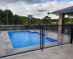 an empty swimming pool is seen through the fence