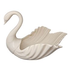 a white swan shaped bowl sitting on top of a table