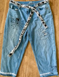 a pair of jeans with spider webs on them