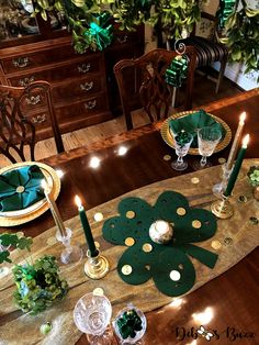 the table is set with candles, plates and napkins for st patrick's day