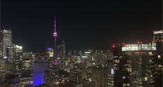 the city skyline is lit up at night with bright lights and skyscrapers in the background