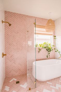 a bathroom with pink tiles and a white tub