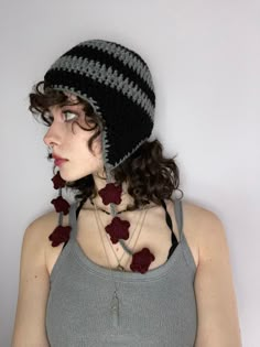 a woman wearing a knitted hat with flowers on the front and back of her head