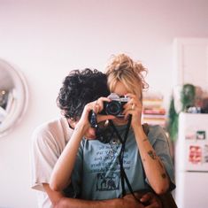 a man and woman are taking pictures in the mirror