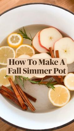 a bowl filled with lemons, apples and cinnamon sticks on top of a wooden table