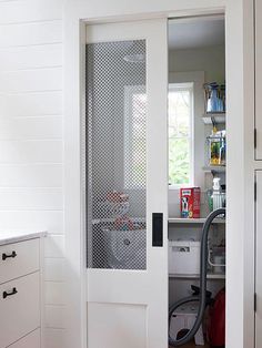 an open door in a kitchen with a vacuum on the floor