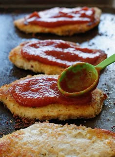 chicken parmesan is being spooned with ketchup