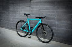 a blue bike leaning against a gray wall