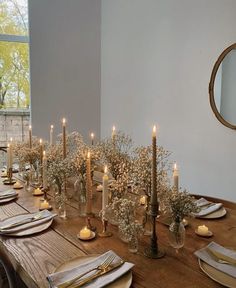 a long table is set with candles and place settings