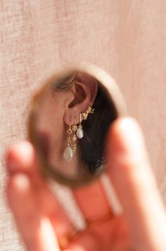 a close up of a person holding a magnifying glass to their face and looking in the mirror