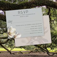 a wedding card with a flower on it sitting in the middle of a tree branch