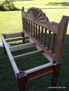 a wooden bed frame sitting in the grass