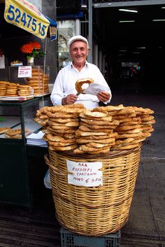 a man standing behind a large basket filled with donuts