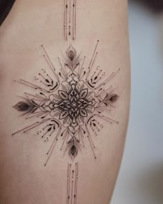 a woman's thigh with an intricate tattoo design on the side, and arrows coming out of it